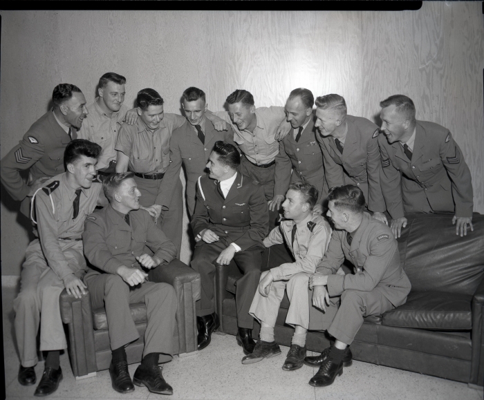 Black and white photo of NATO pilot trainees and airmen at No. 4 Flying Training School chat in a promotional photograph