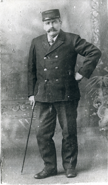 Black and white portrait of Cornelius Mifflin, Red Deer's first police officer, in his police officer's uniform