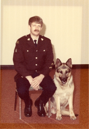 Coloured photo of one officer and one police dog in an RCMP unit in Red Deer