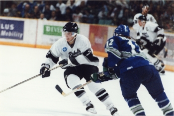 Coloured photo of Red Deer Rebels player deking past a Swift Current Broncos during a game at the Centirum