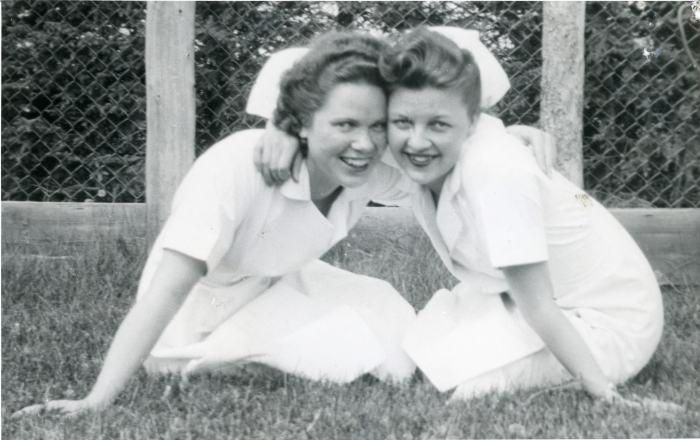 Black and white photo of two young women in nurses outfits, including white cap and white dresses in 1930s in Red Deer, Alberta