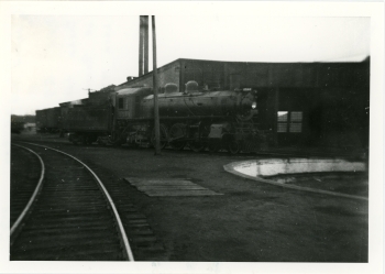 Black and white photo of Canadian Pacific Railway's (CPR) G-3 steam locomotive in front of the roundhouse in Red Deer