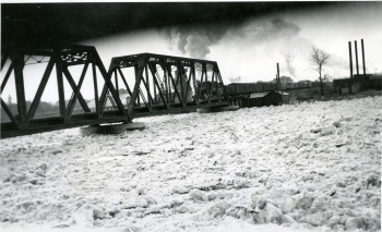 Black and white photo of the Canadian Pacific Railway (CPR) bridge across the Red Deer River during a spring ice jam,