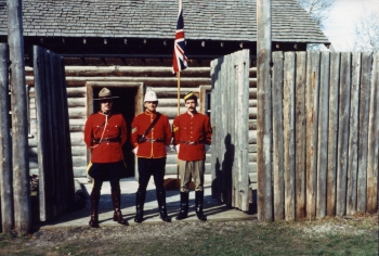 Coloured photo of three men dressed as North West Mounted Police at Fort Normandeau