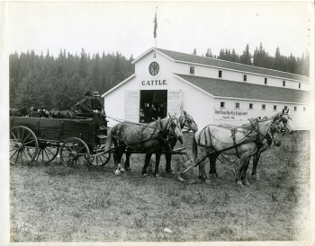 Black and white photo of  the Great West Lumber Company's wagon at the 1912 Red Deer fair, outside the cattle pavilion