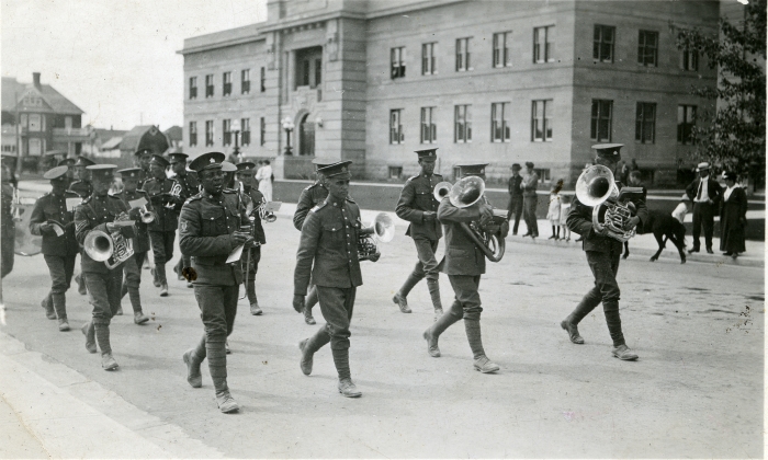 Black and white photo of the 187th Battalion brass band marching, most likely in Calgary