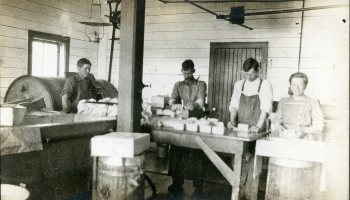 Black and white photo of men standing in Trimble Creamery, wrapping butter around 1911.