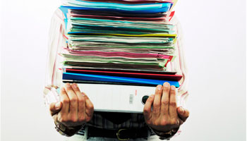 photo of hands holding a stack of books and files