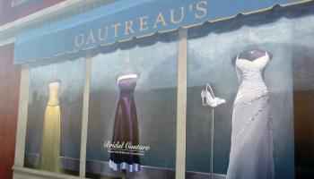 Painted mural of dresses hanging in a store front window.
