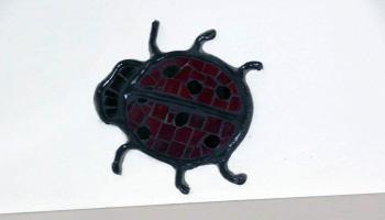 Glass mosiac tiles in the shape of a lady bug over a door frame