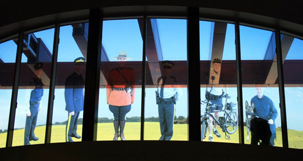 Glass windows with an multiple RCMP officers if different uniforms etched in the glass.