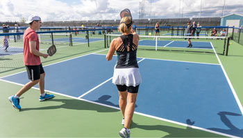 Players on a pickleball court playing pickleball